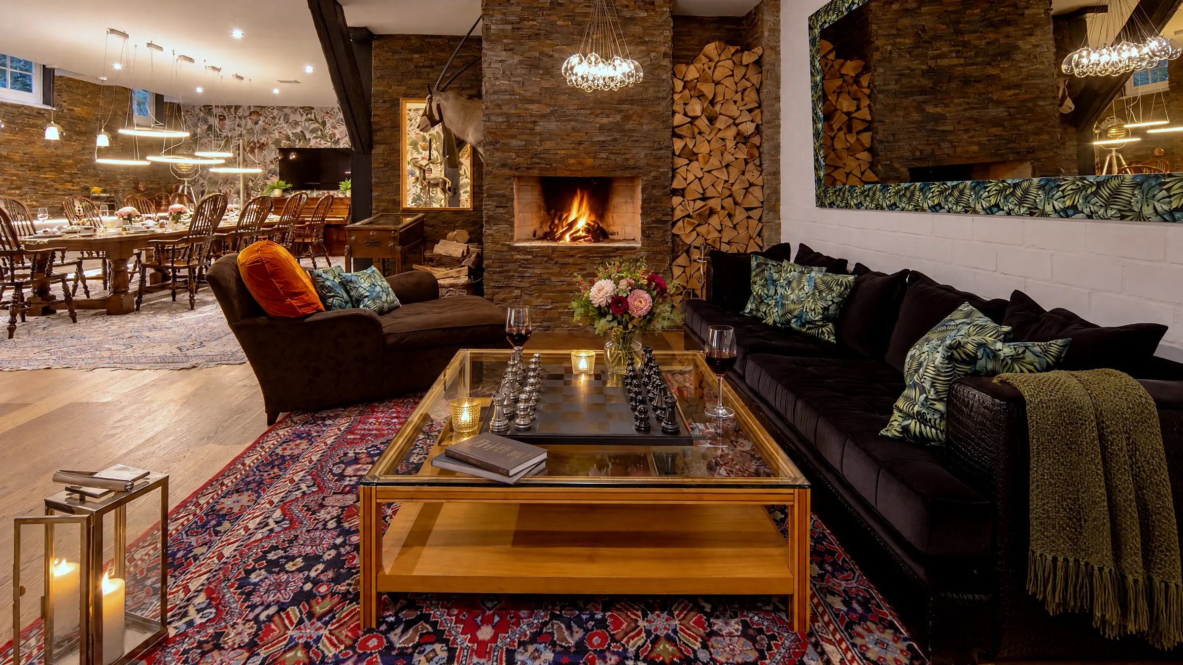 Kaminlounge mit brennendem Feuer und Sesseln