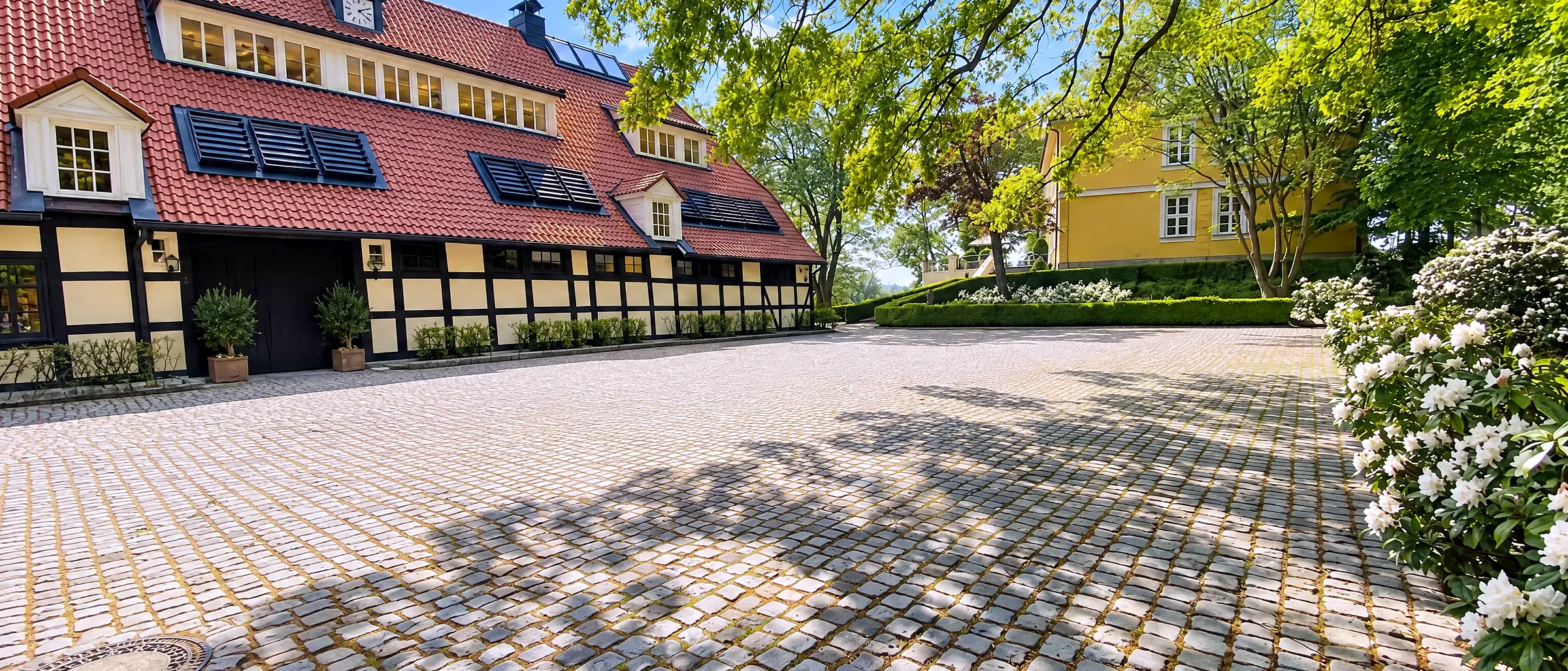 Der Innenhof der Schlossresidenz mit Kopfsteinpflaster, alter Linde und Fachwerkflügeln in der Abendsonne